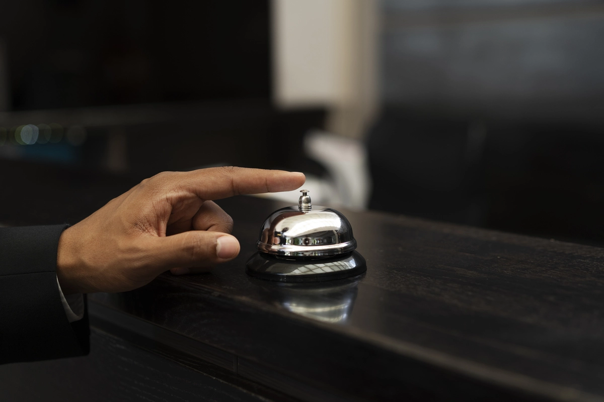 Uma pessoa sendo atendida em um hotel que é composto por profissionais que fizeram o curso de hotelaria.