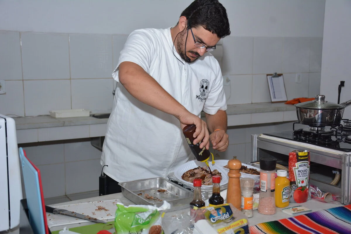 Um professor do curso de manipulação de alimentos preparando um prato.