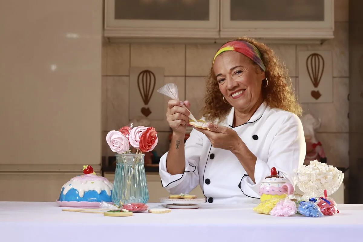 Uma mulher segurando os produtos que vende em seu negócio, que segue as diretrizes da COP 30 para metas climáticas.